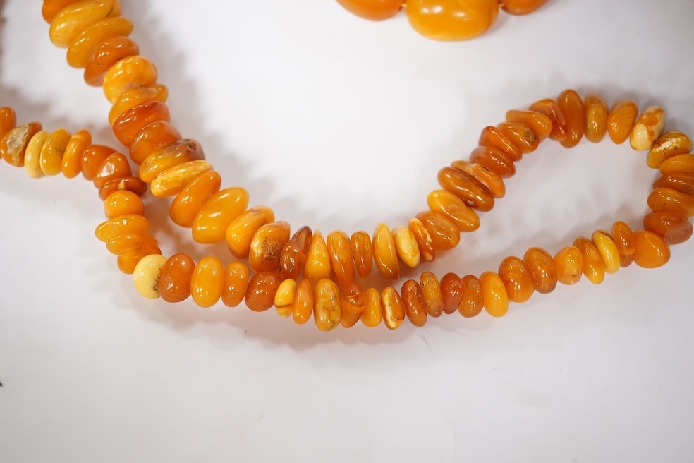 Three assorted amber necklaces including a single strand graduated oval bead necklace, 40cm, gross weight 37 grams, the other two necklaces gross weight 240 grams. Condition - poor to fair
